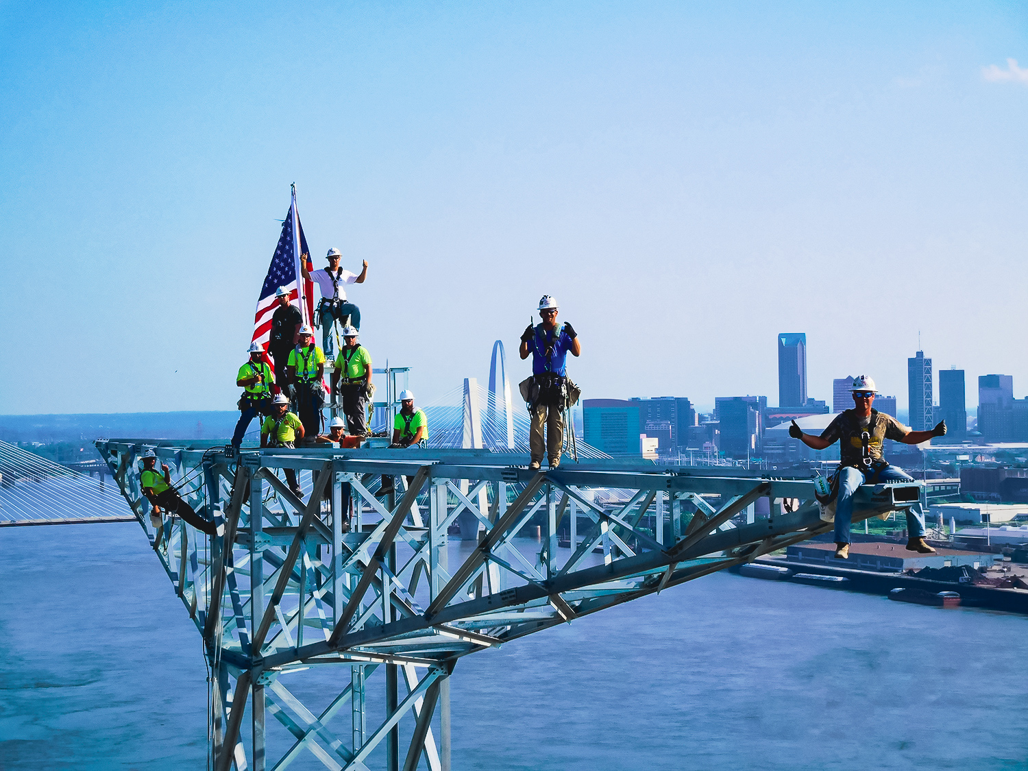 Workers standing on the top of a transmission tower