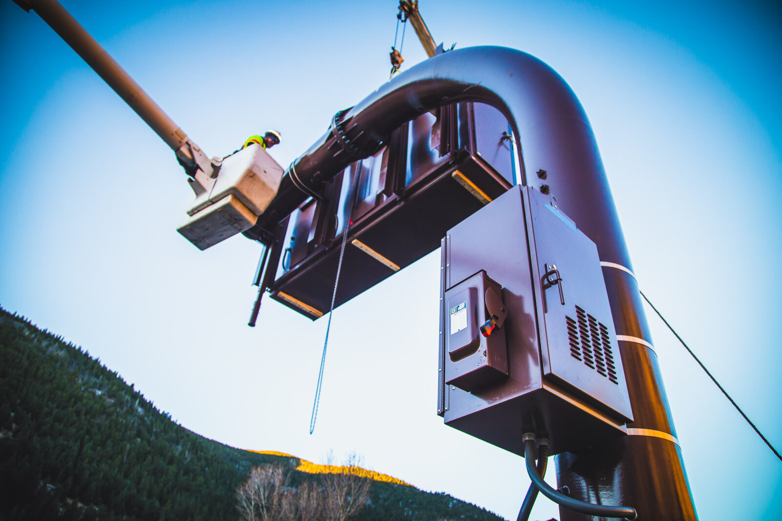 Worker on a elevated platform installing a transformer