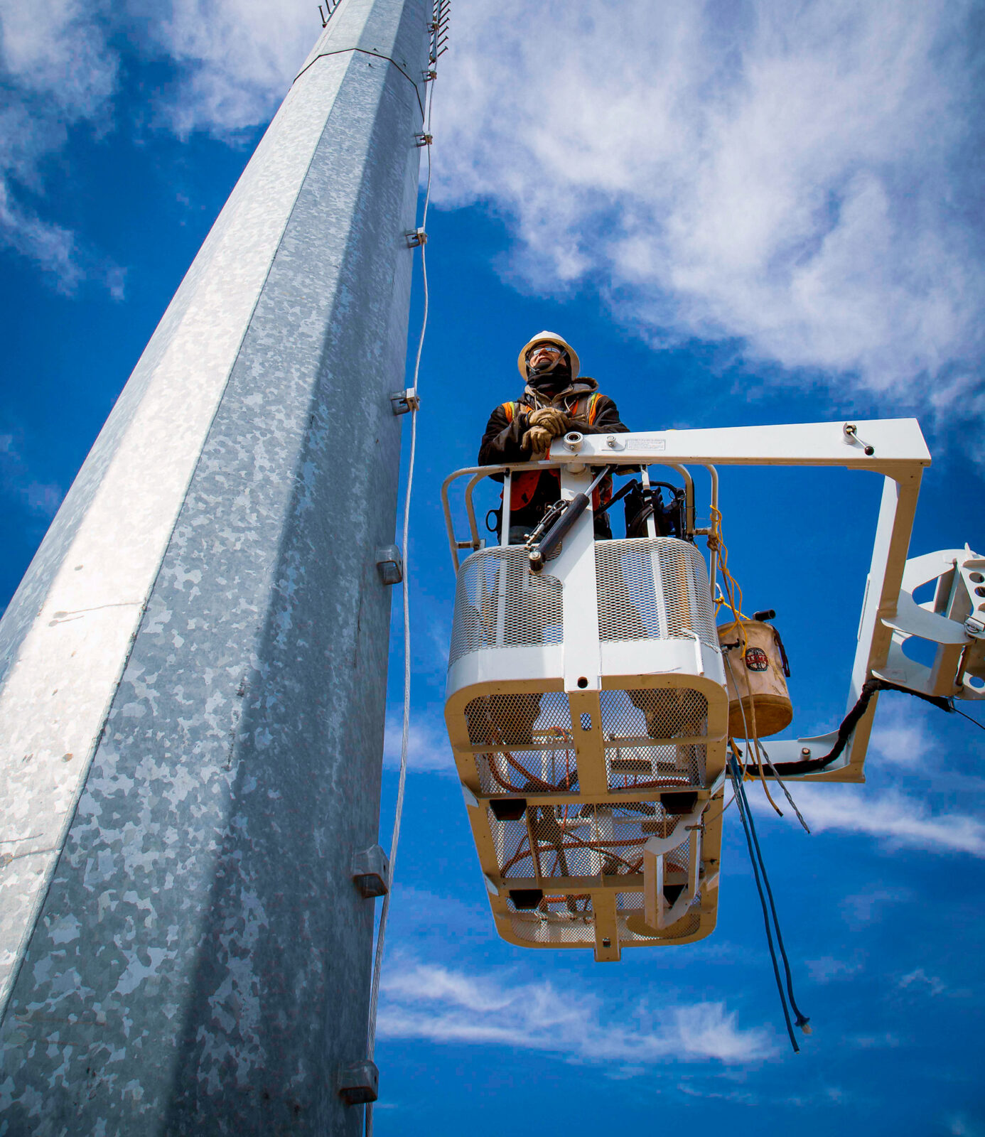 Construction worker on elevated platform beside a tower