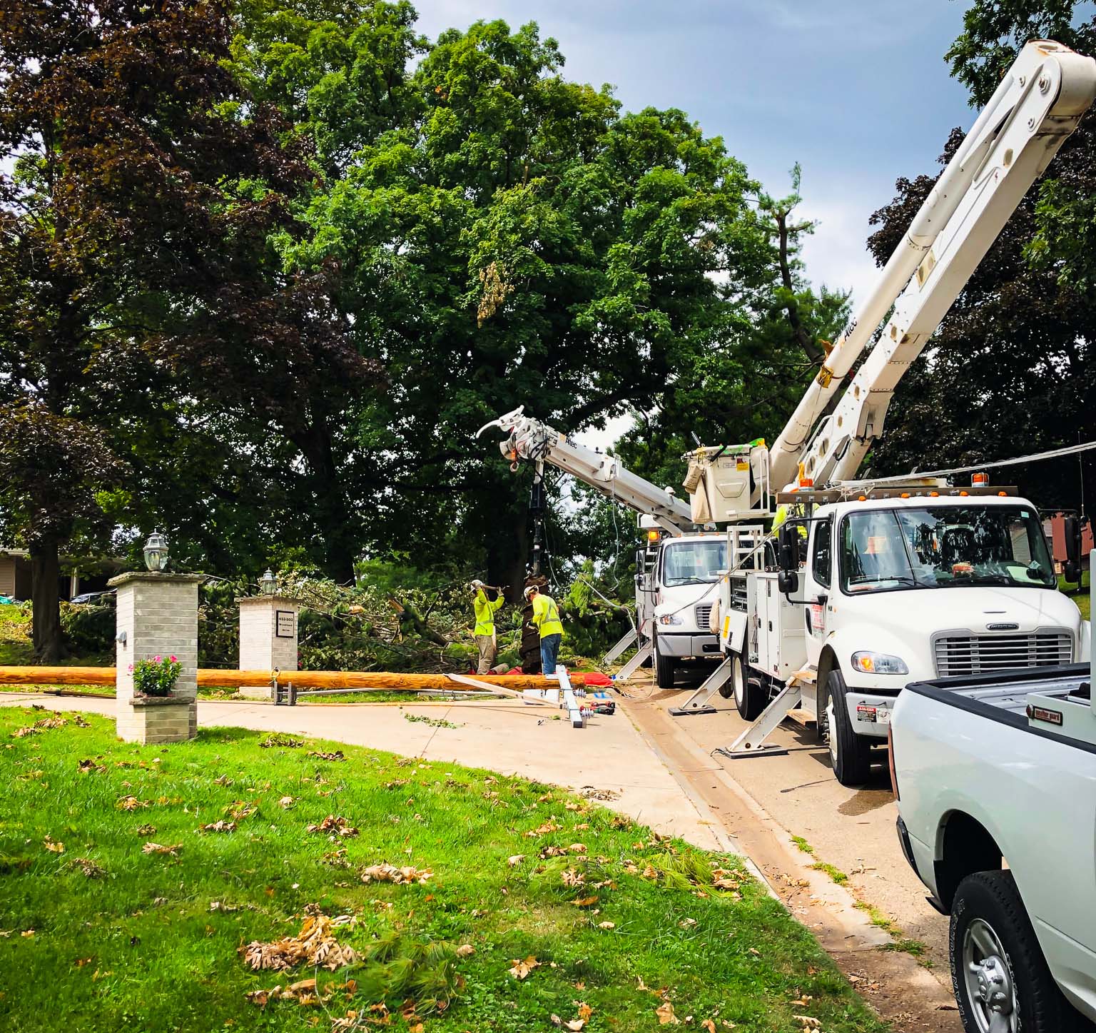 Restoration workers preparing to lift a damaged power line pole