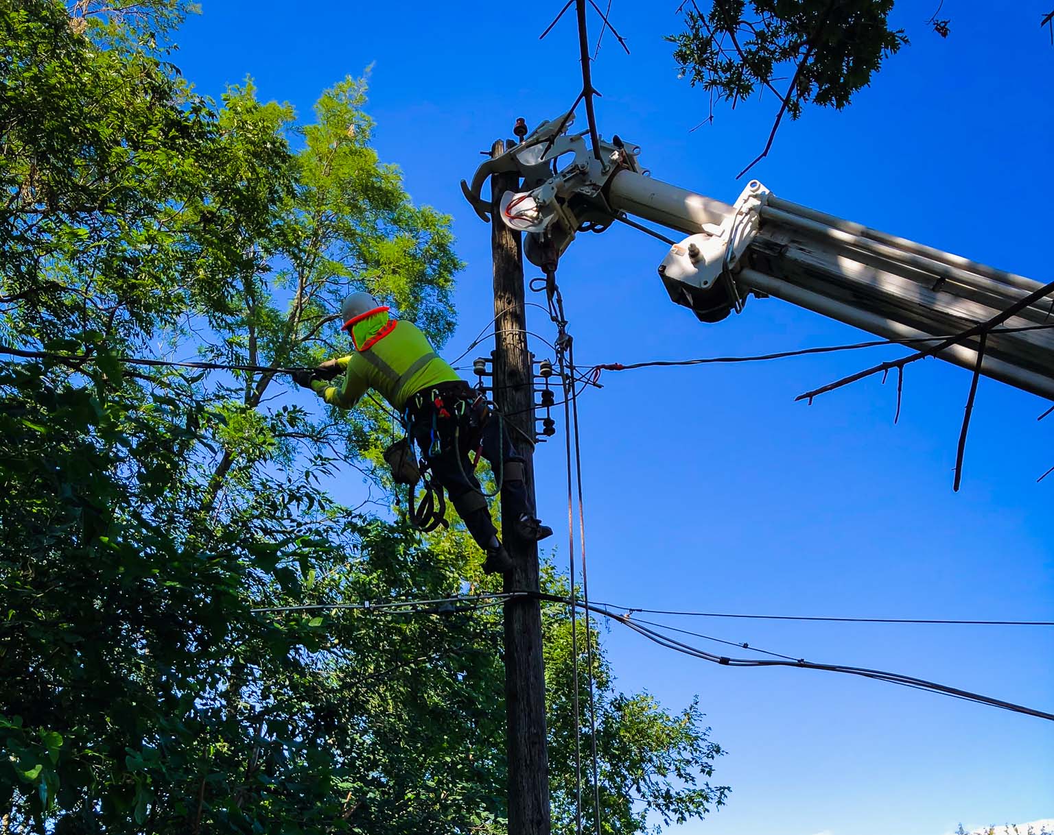 Construction worker adjusting wires on a power line
