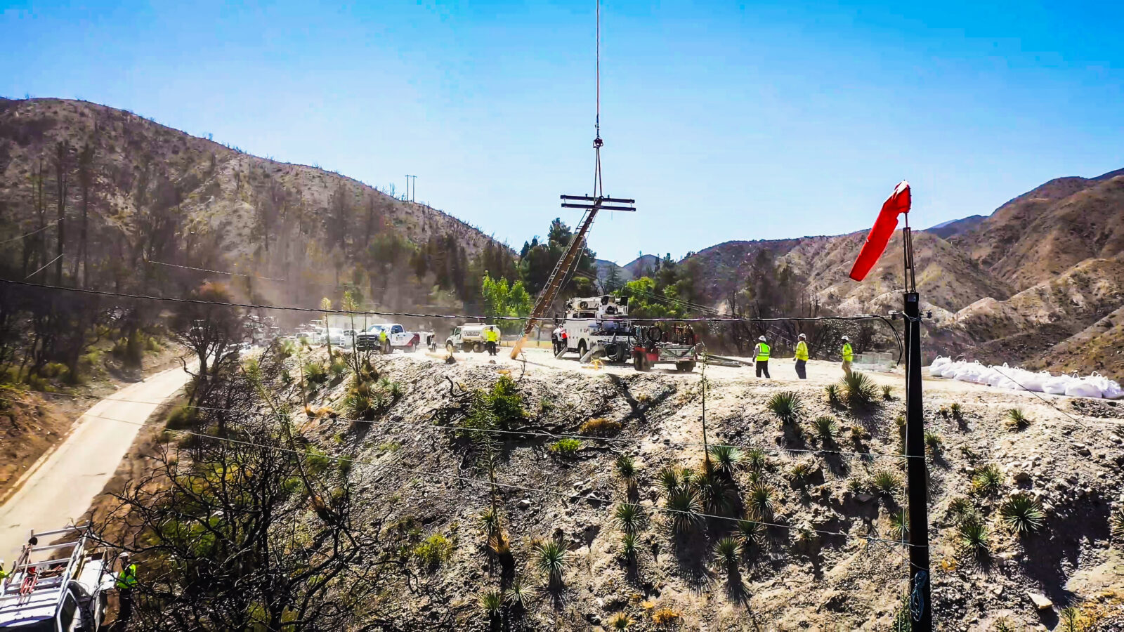 Harlan Electric workers lifting a power line pole using a crane