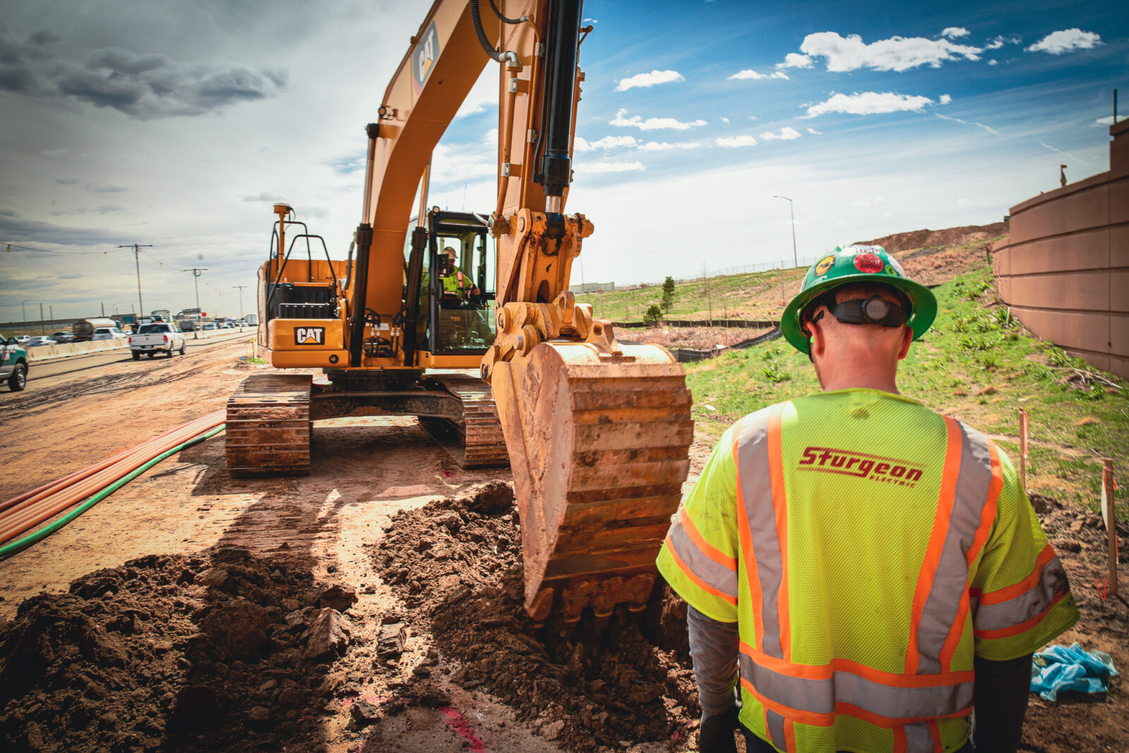 Man observing excavator pick up dirt