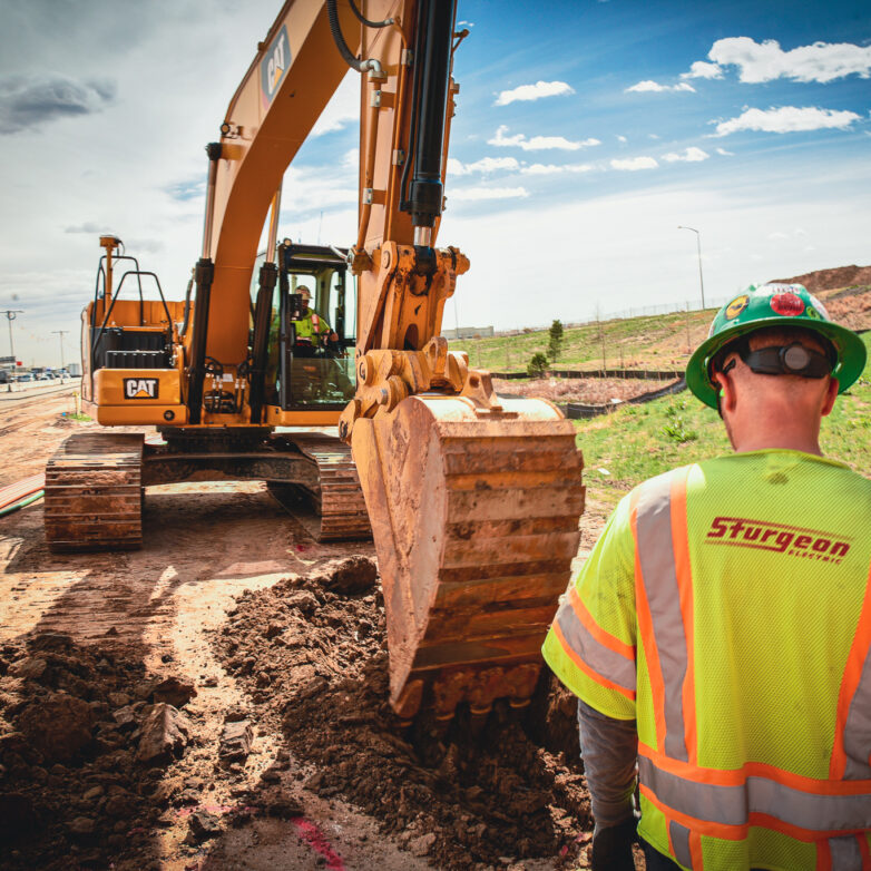 Man observing excavator pick up dirt