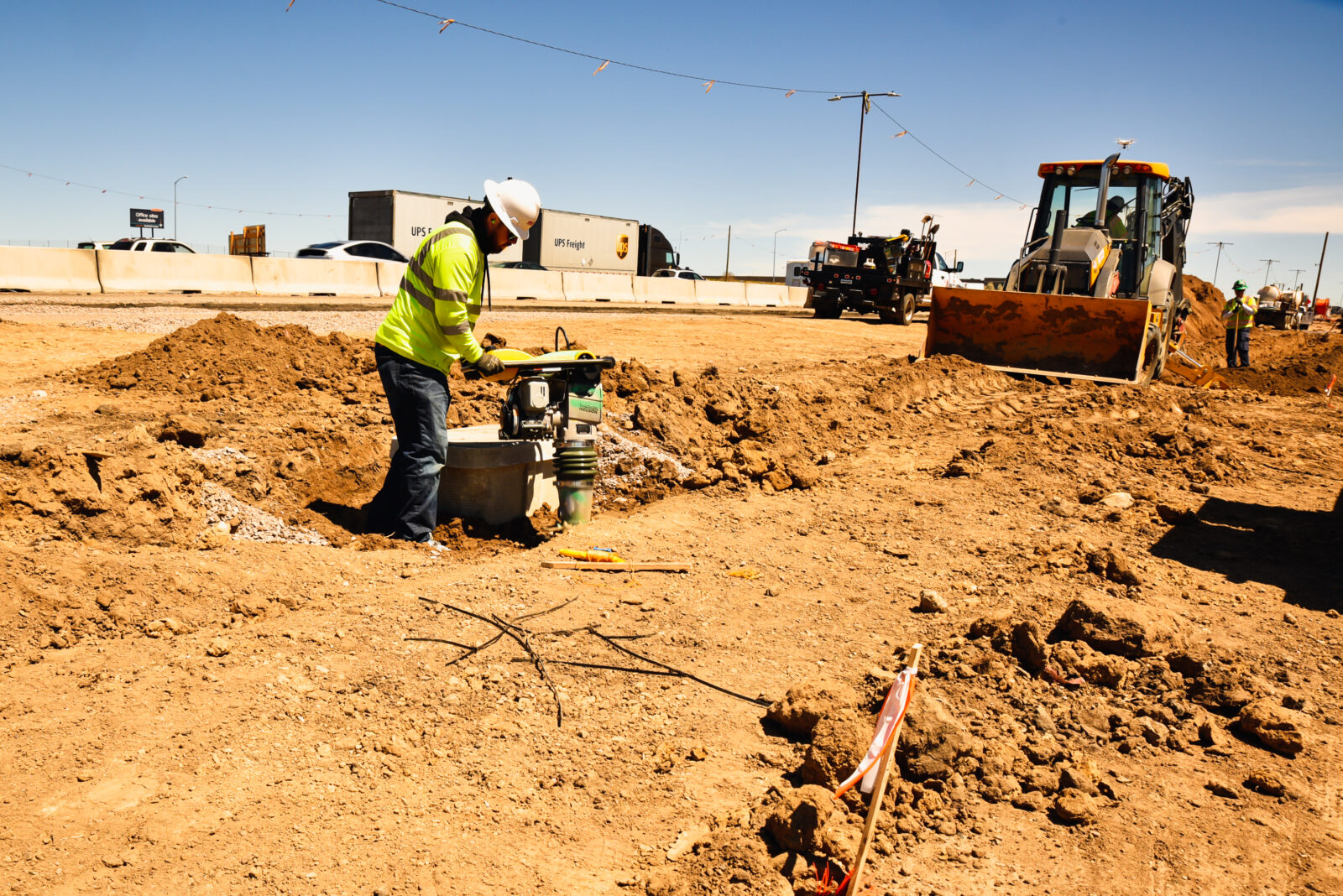Construction worker using machinery to dig into the dirt