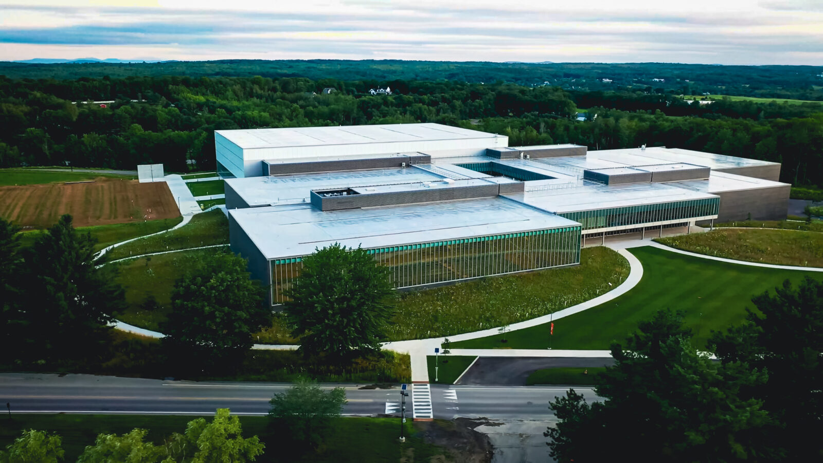 Angled aerial view of Colby Athletic Center with green grass in front of the building