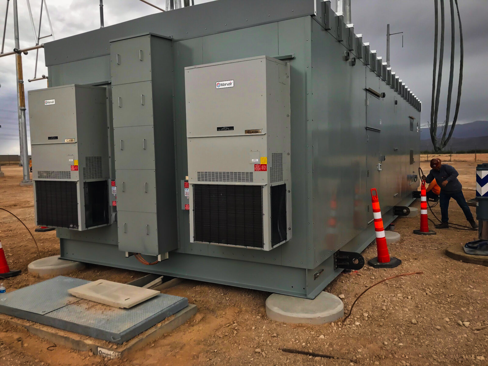 Construction worker beside a transformer