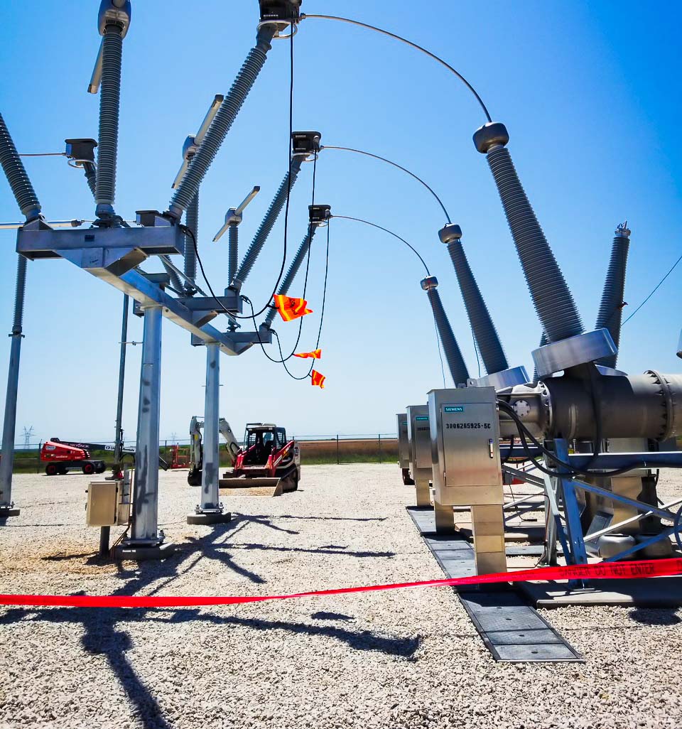 Substation with a red excavator in the distance