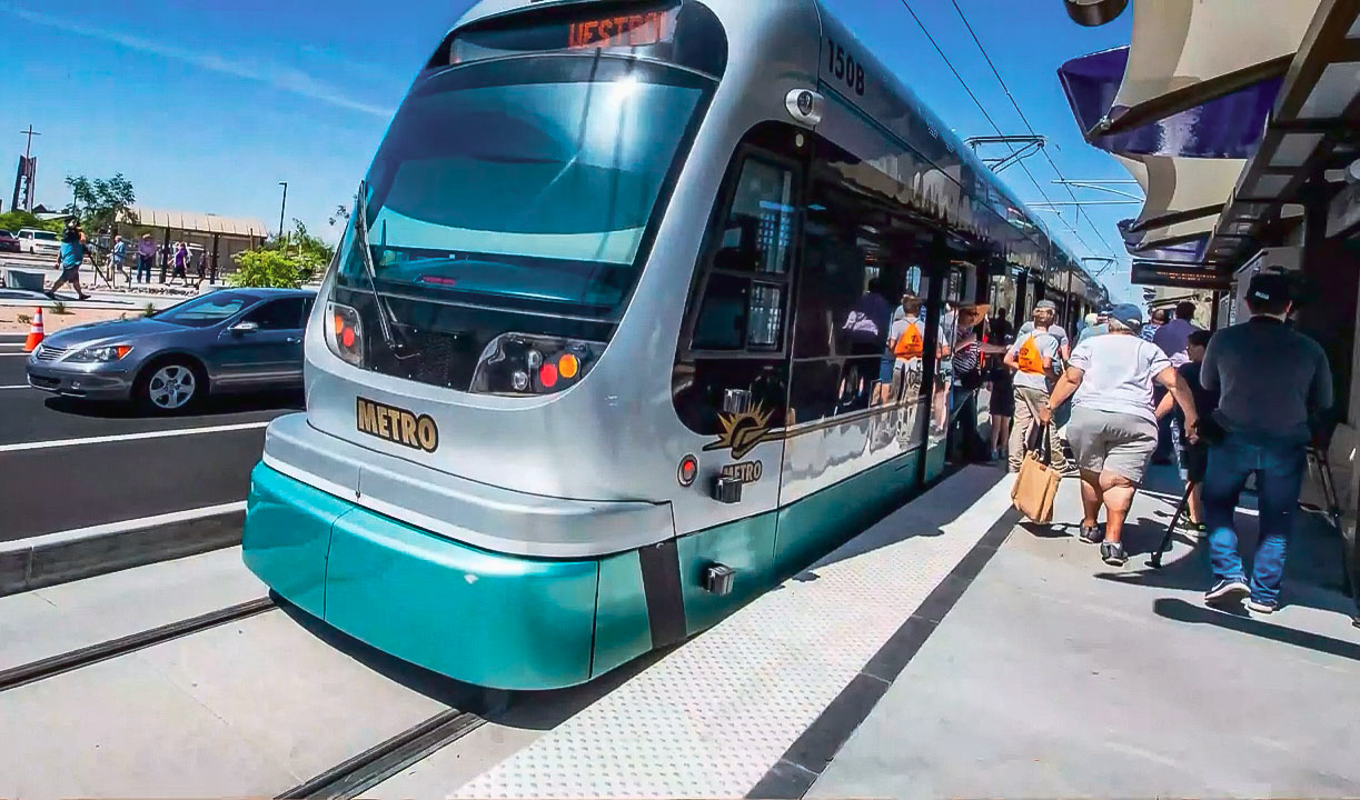 Front of light rail train with people entering and leaving the train