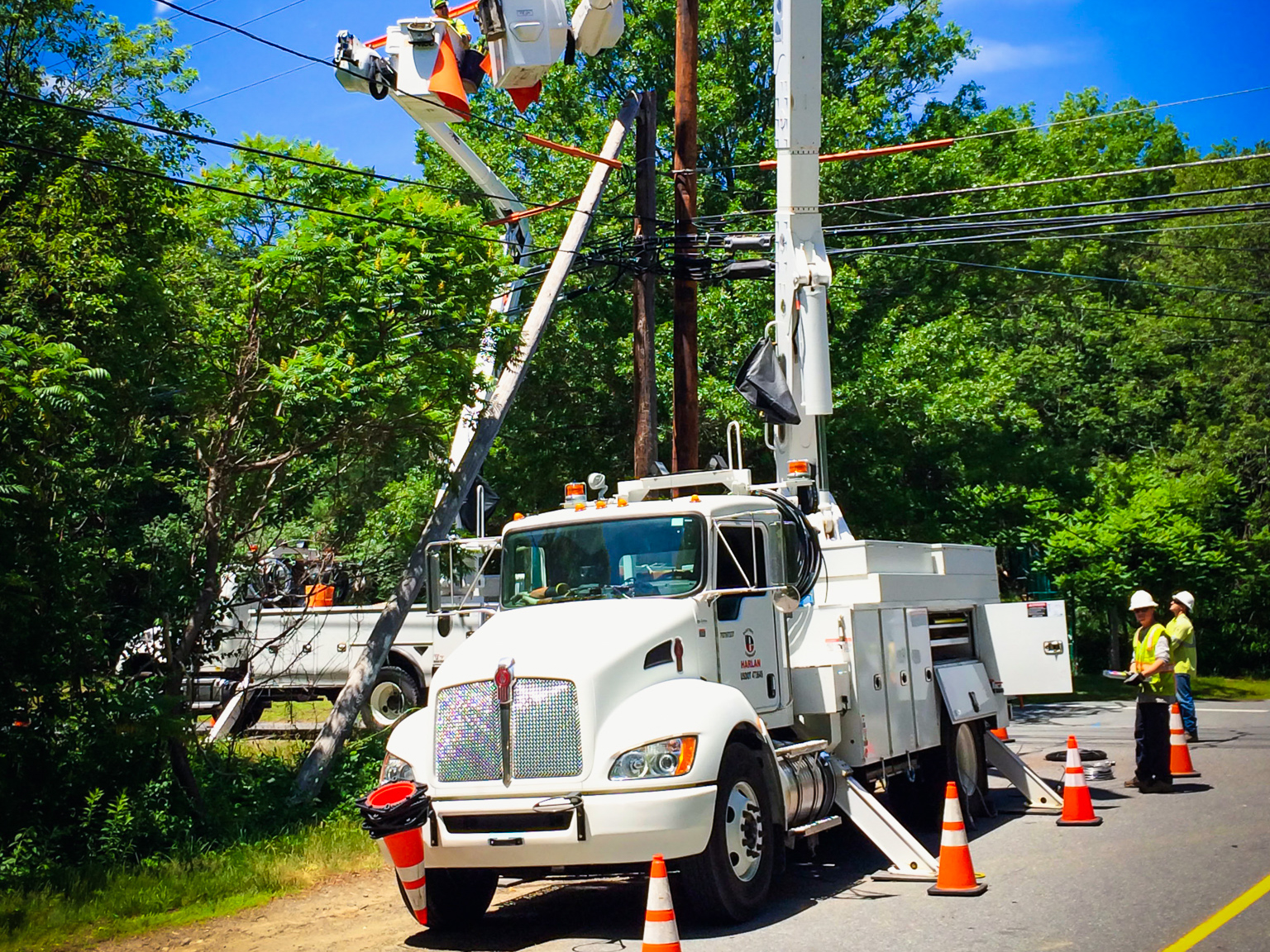 White bucket truck beside a power line