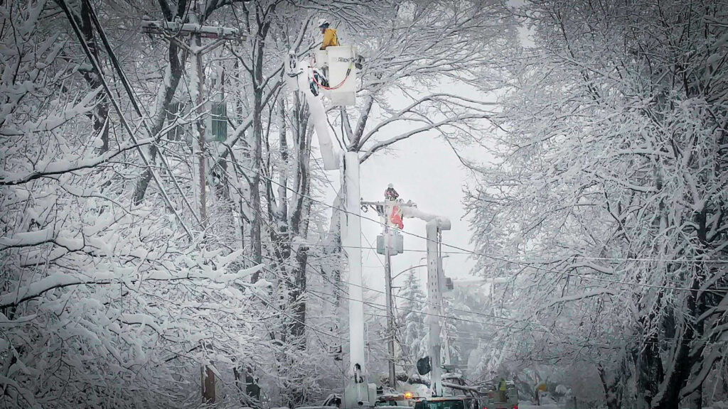 Two workers restoring power lines in the snow