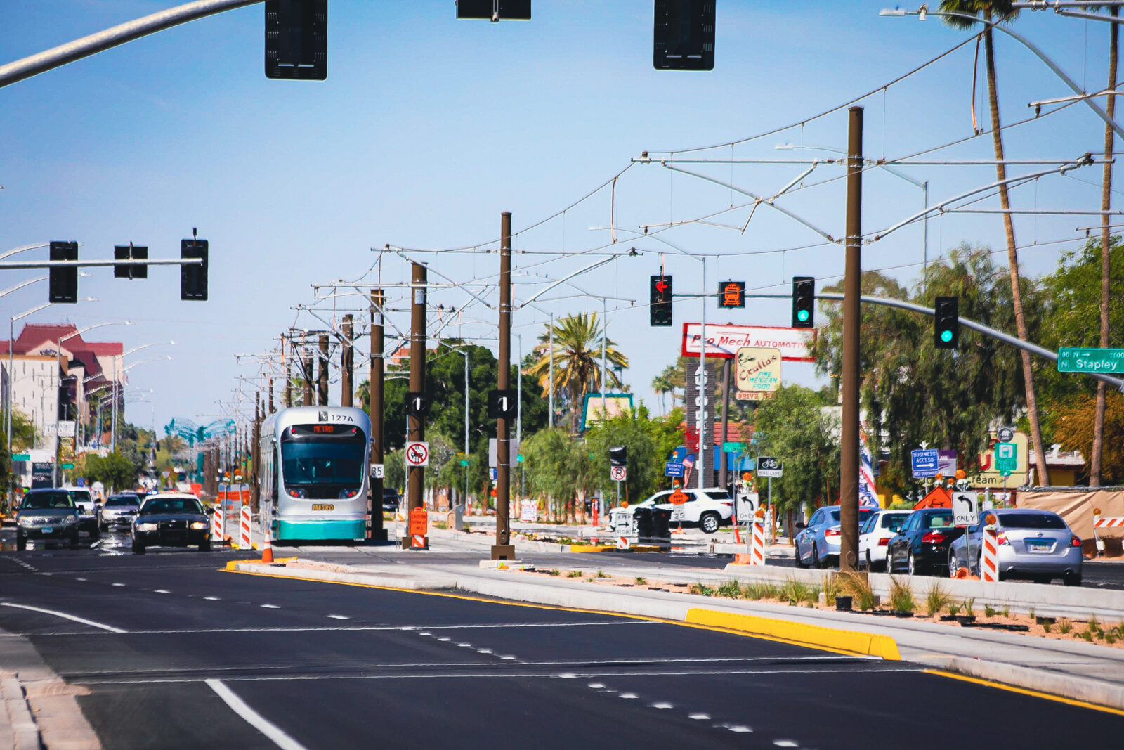 Busy street with cars and light rail train