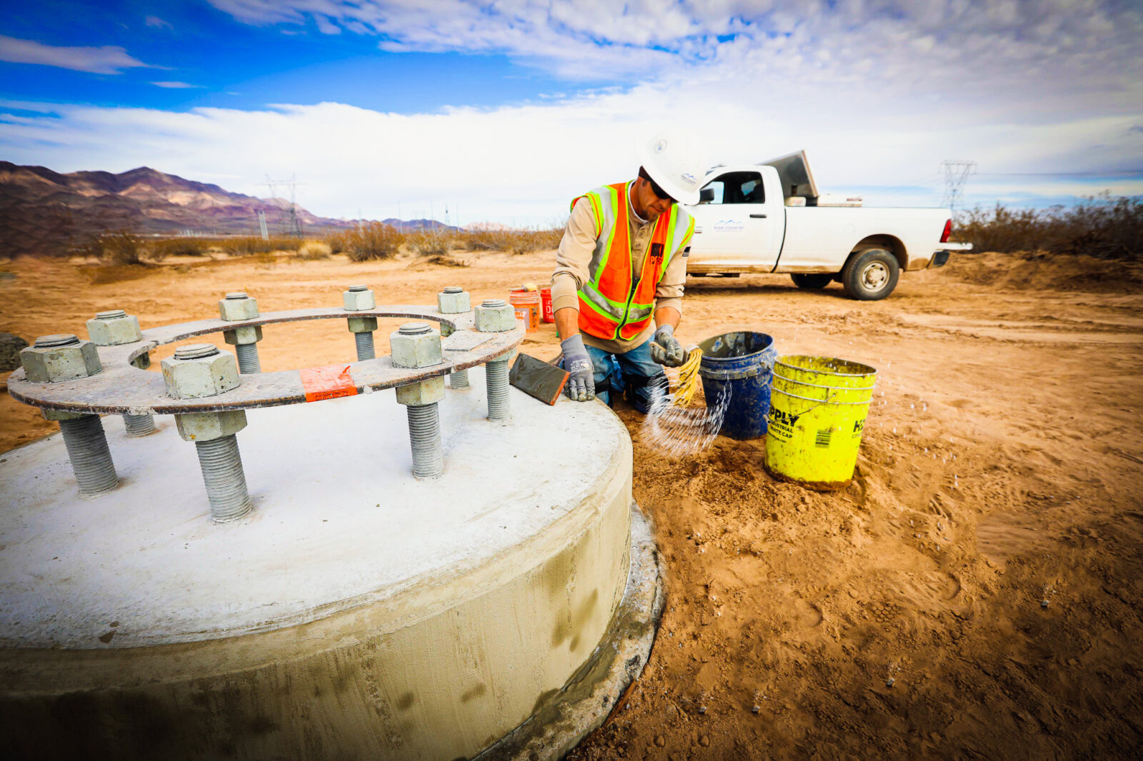 Construction worker applying liquid to a concrete base
