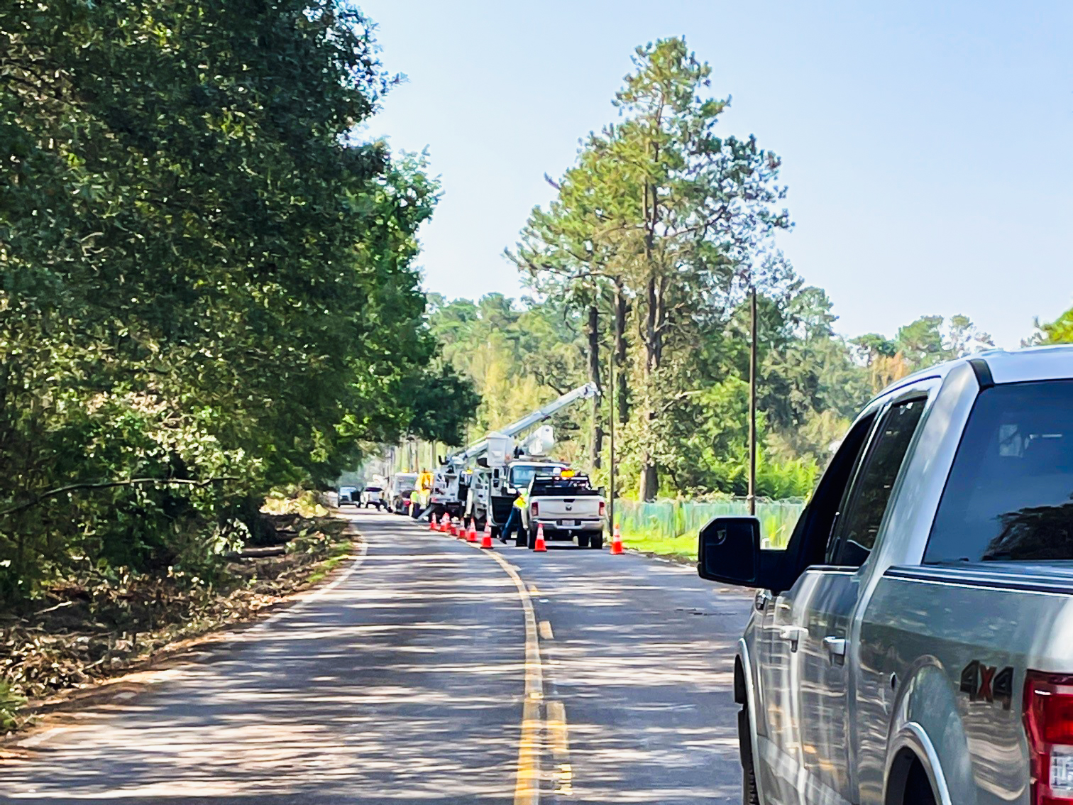 Construction workers placing pylons on a two-way road