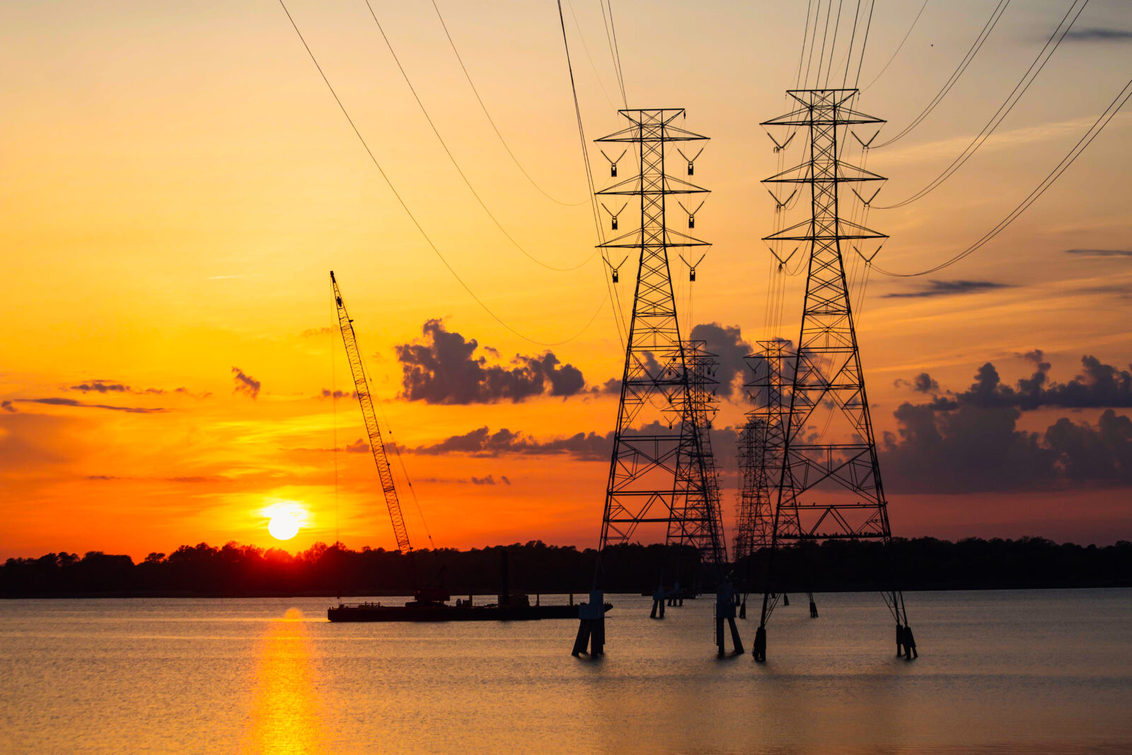 Two transmission towers during a sunset