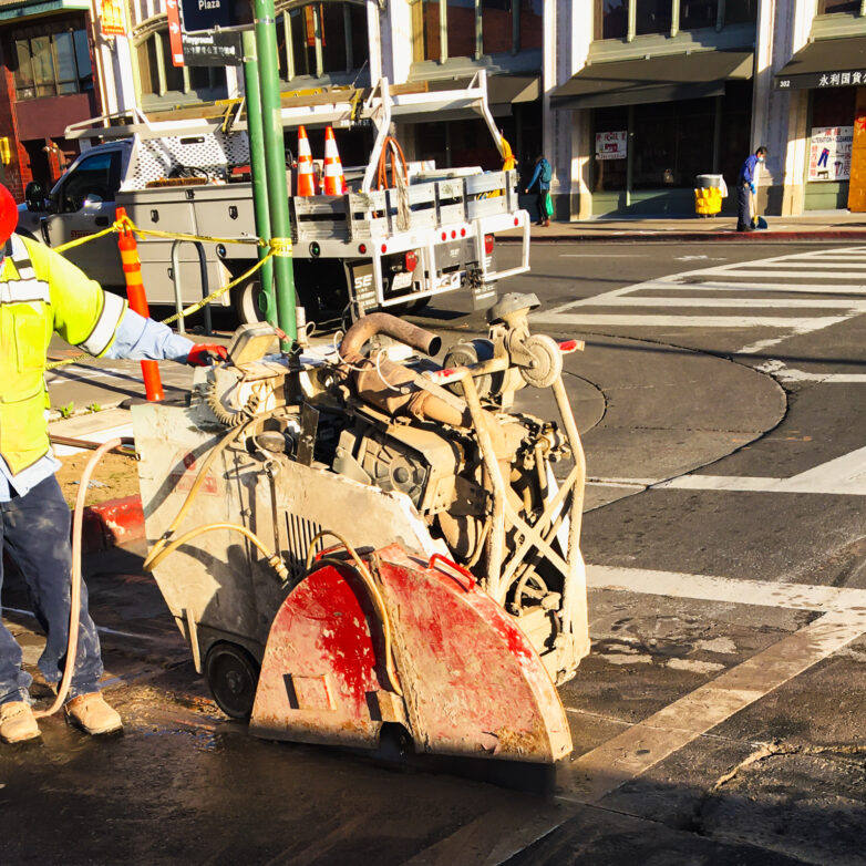 Harlan Electric worker using machinery to smooth road surface