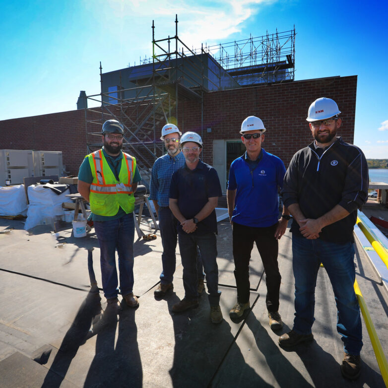 five men in hard hats smiling