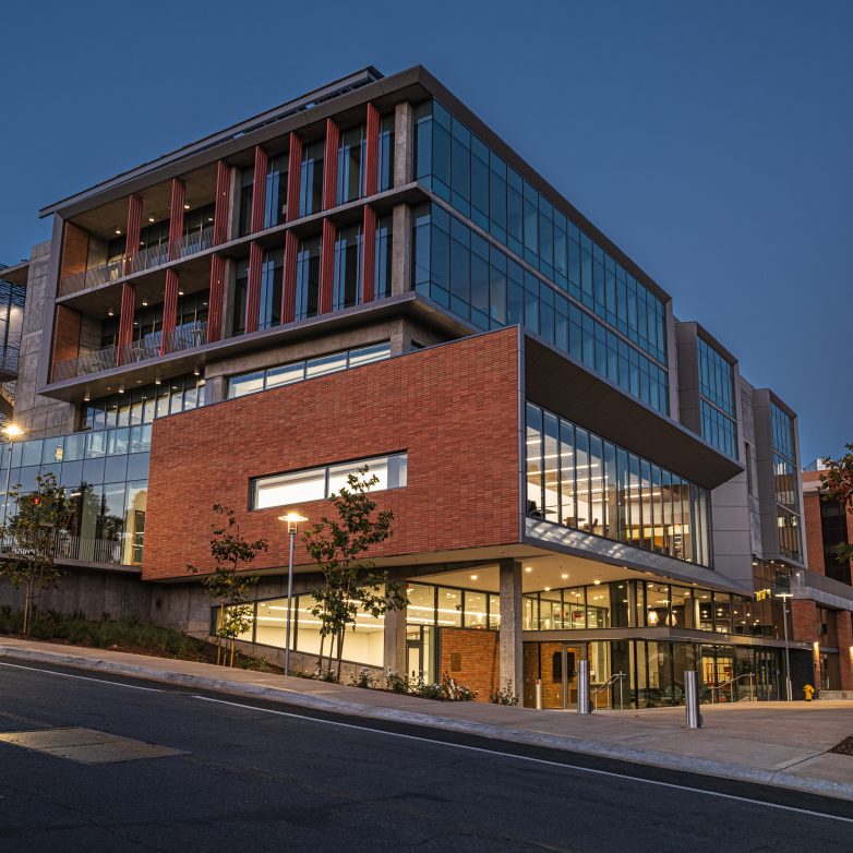 a large building with many windows lit at dusk