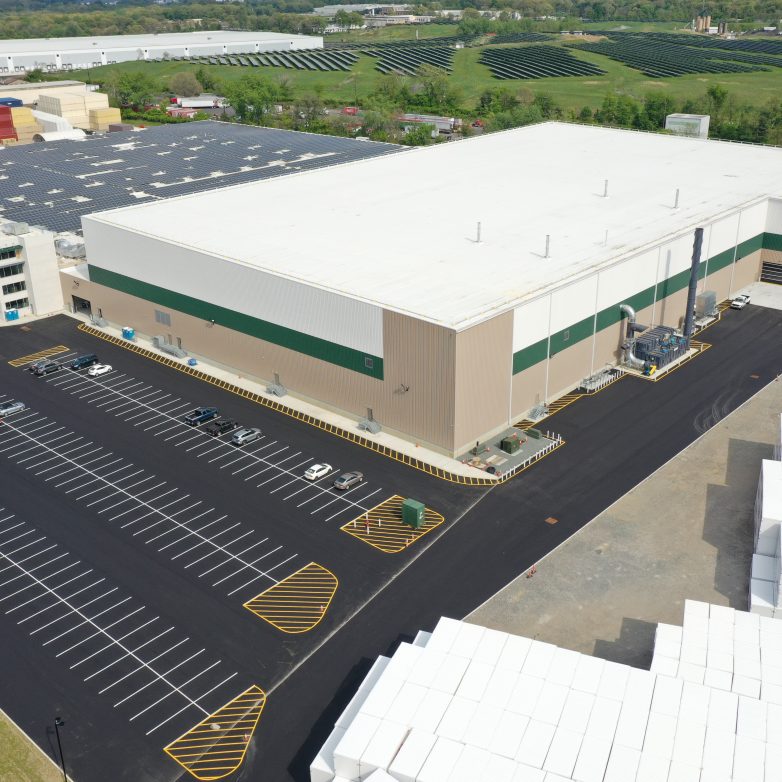 A large warehouse with a parking lot